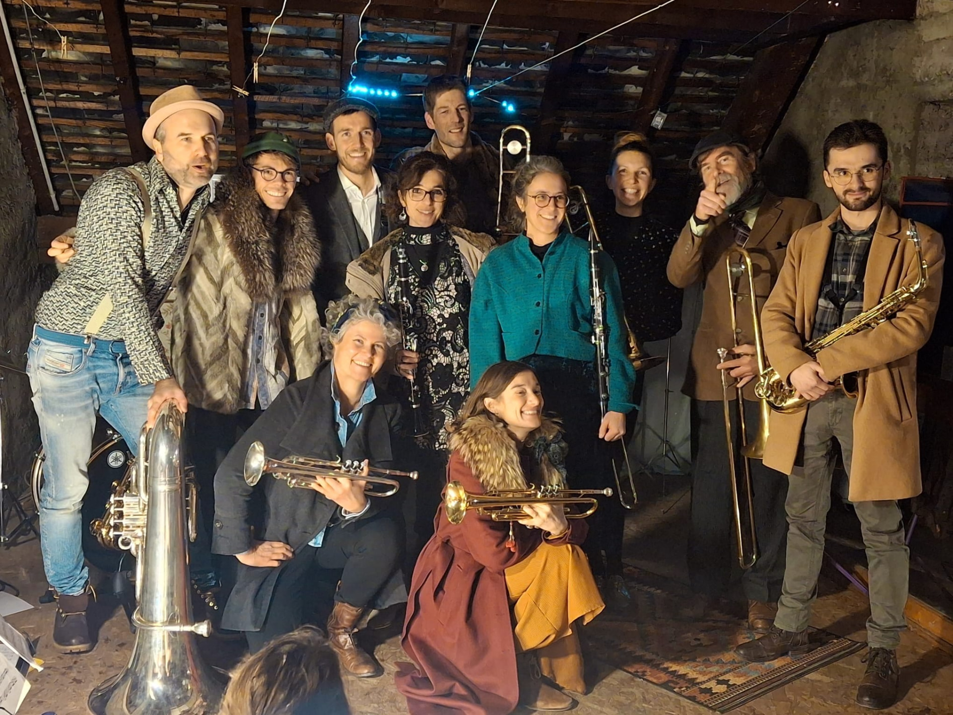 Les musiciens d'Attico Brass réunis dans un grenier en bois, instruments à la main